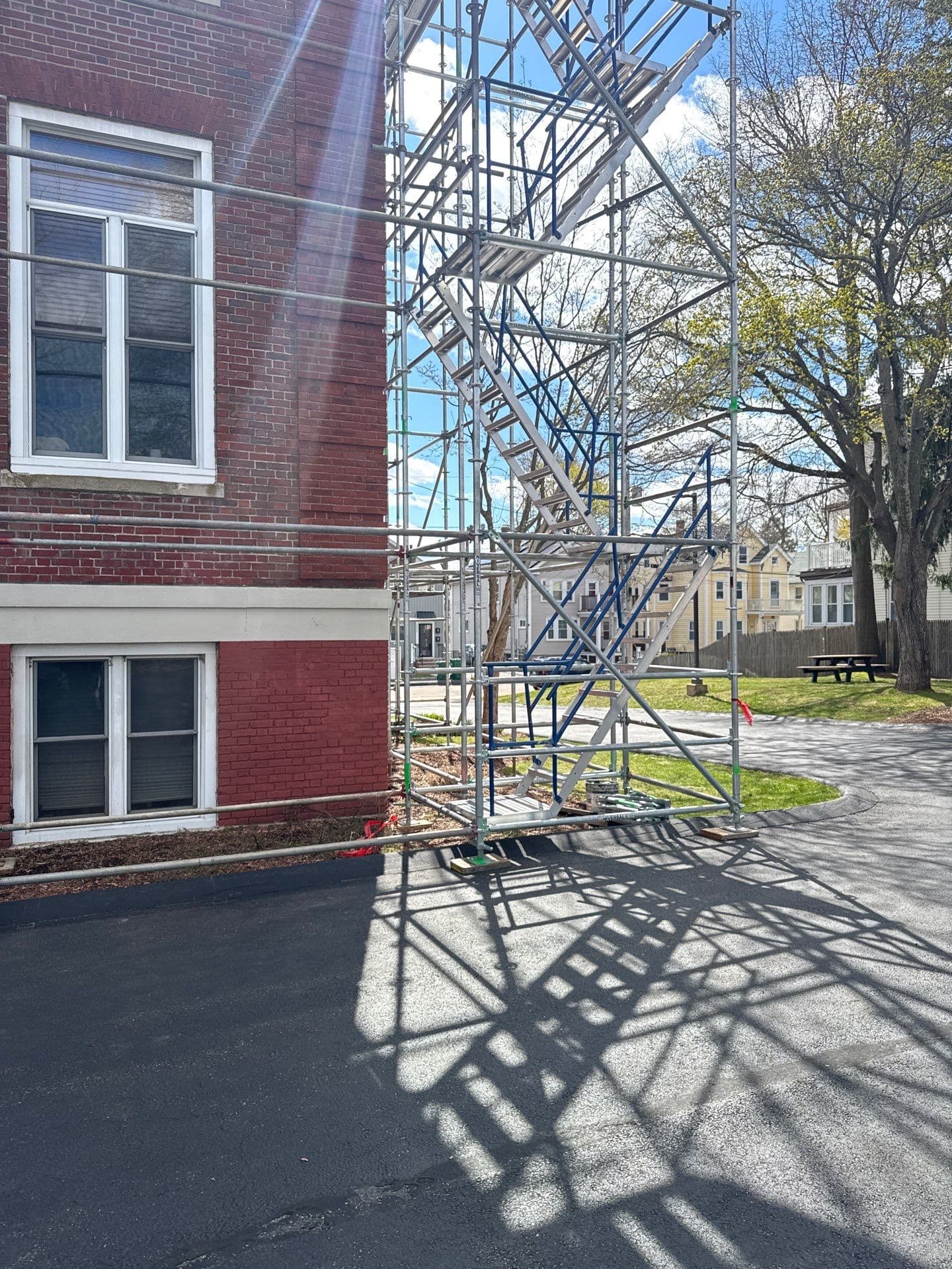 Scaffold access tower with stairs and platforms beside the brick facade at Sharon Street